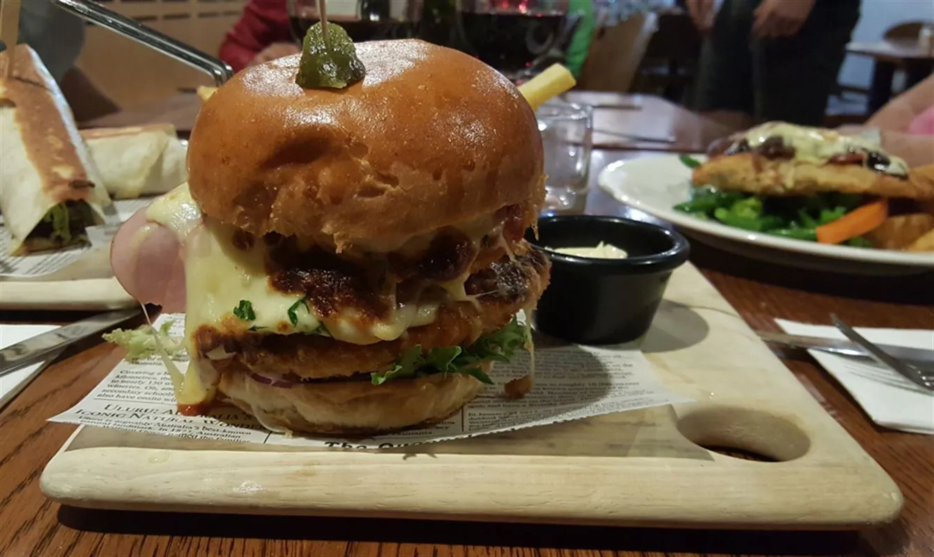A loaded burger on a serving board