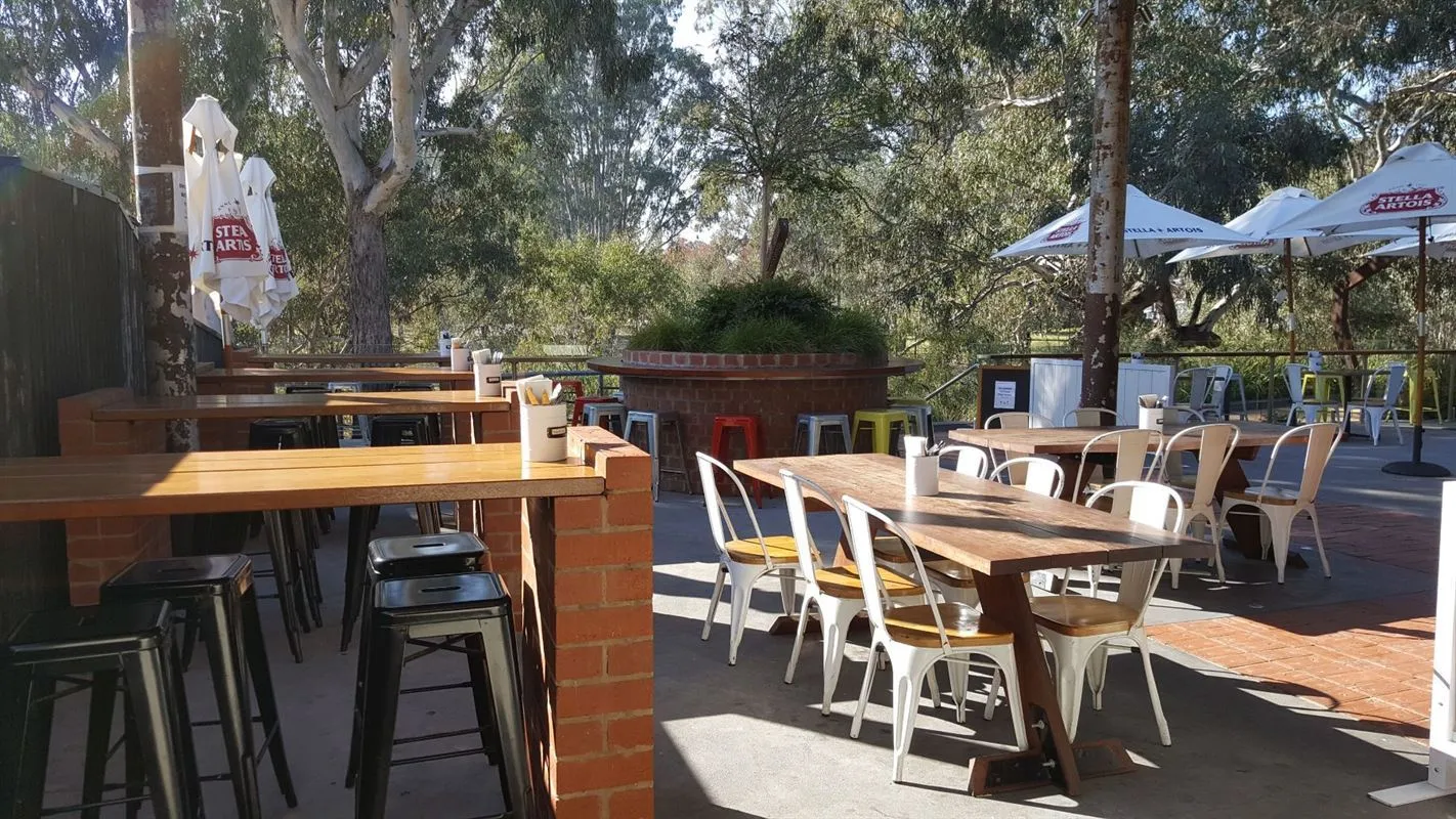 The sunny deck at Precinct with tables and umbrellas
